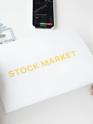 Business theme with stock market document, currency, and mobile display.