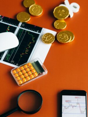 Stock market and financial analysis setup with calculator, graphs, and gold coins.
